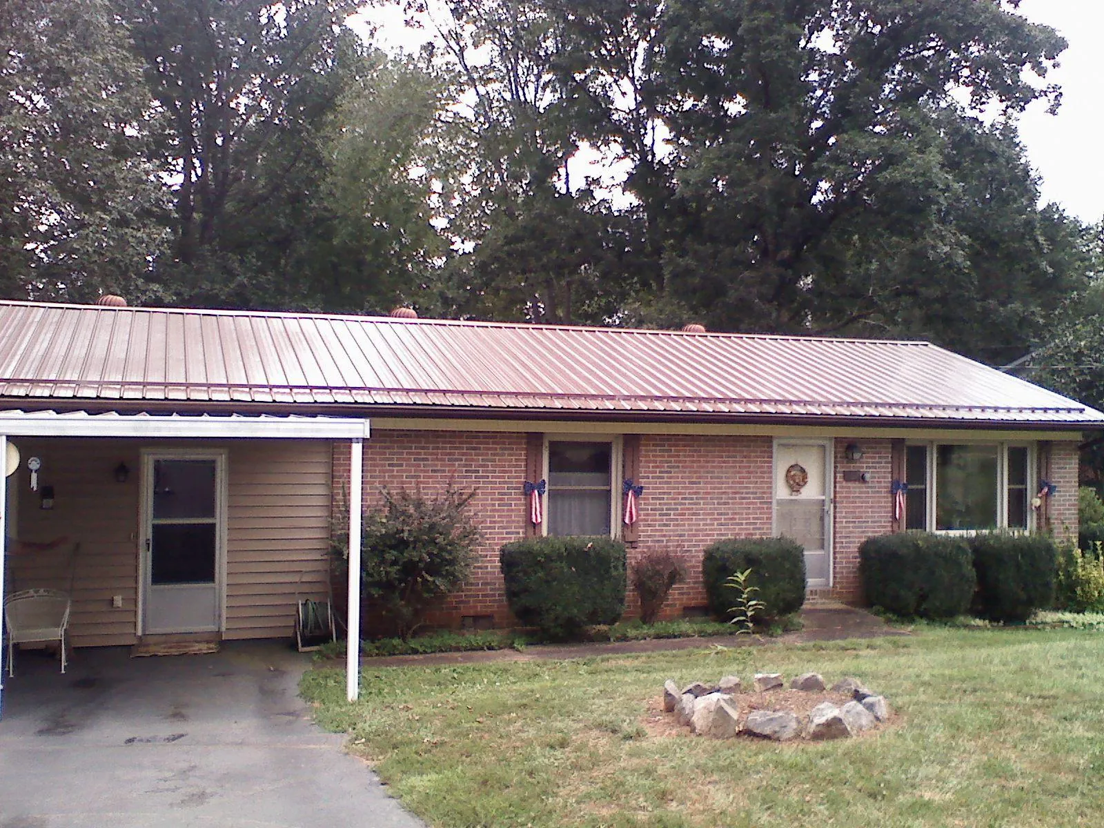 Bronze metal roof and carport on a brick ranch home — Roof Repair work by our crew in Cunningham